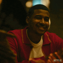 a man wearing a red sweater is smiling in a netflix advertisement