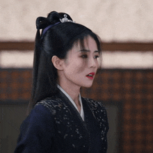 a woman with a tiara on her head is wearing a blue jacket