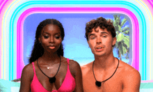 a man and a woman are standing next to each other on a beach