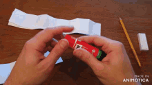 a person is holding a stick of glue that says made in animatica on it