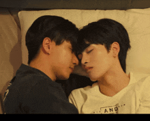 two young men are laying next to each other with one wearing a shirt that says nic and