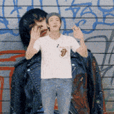 a man in a rolling stones shirt is standing next to another man in a leather jacket