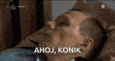 a man laying on a bed with the words " ahoj konik " written above him