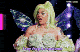 a drag queen with green hair and wings says drag is a costume