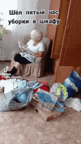 a woman is sitting in a chair reading a newspaper in a messy room