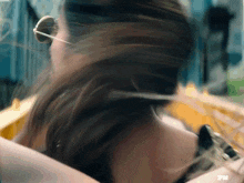 a woman 's hair is blowing in the wind in a blurry photo with a fn logo on her arm