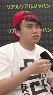 a man wearing a red hat and a t-shirt that says ' rkc ' on it