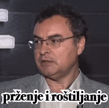 a man wearing glasses and a white shirt has the words " przenje i rostiljanje " written on his face