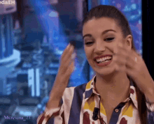 a woman wearing a striped shirt is smiling and making a face