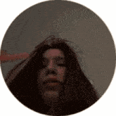 a woman 's face is visible in a circle with her hair blowing in the wind .