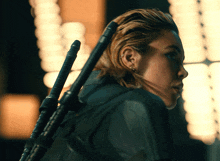 a woman with a piercing in her ear holds a sword