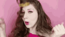 a woman is holding a fork in her hair and making a heart shape with her hands .