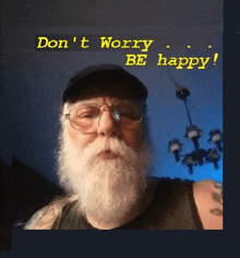 a man with a beard wearing glasses and a hat with the words " don 't worry be happy " above him