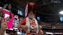 a man wearing a chiefs hat and a chiefs emblem