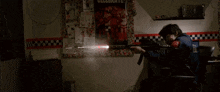 a person holding a gun in front of a poster that says " celebrate "
