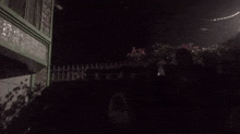 a group of people are standing in front of a house at night .