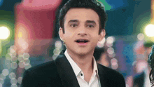 a man in a tuxedo and white shirt is looking at the camera with his mouth open