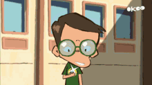 a cartoon of a boy wearing glasses and a green shirt with the letters ok on the bottom