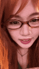 a close up of a woman wearing glasses and a green shirt