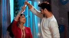 a man and a woman are dancing together in a living room .