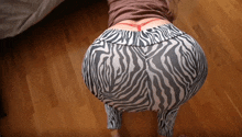 a woman wearing zebra print pants and a red string around her waist
