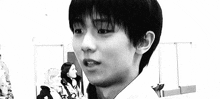 a black and white photo of a young man with short hair .