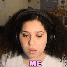a woman wearing headphones says me in pink letters on her face