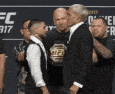 two men standing next to each other in front of a sign that says ufc 317