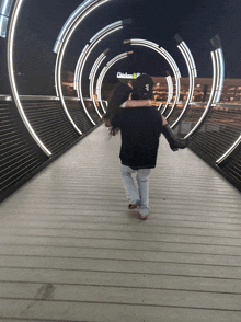 a man carrying a woman on a bridge with a mcdonalds sign in the background