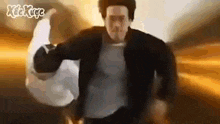 a man in a black jacket is holding a white bag in his hand .