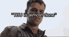 a close up of a man 's face with the words " tbu is almost done " written above him .