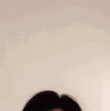 a close up of a man 's face with his eyes closed against a white wall .