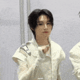 a gif of a young man in a white vest with the letters aa on the bottom