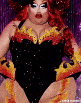 a drag queen with red hair is wearing a black and orange outfit