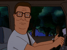 a man with glasses is driving a car