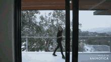 a woman walking through a sliding glass door with the words made in animotica on the bottom