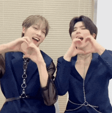 two young men are making hearts with their hands