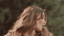a close up of a woman 's face with her hair blowing