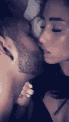 a man and a woman are kissing in bed
