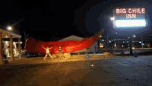 two people standing in front of a big chili inn
