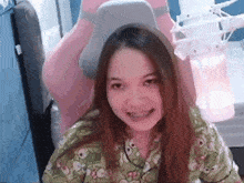 a woman is sitting in a pink chair and smiling