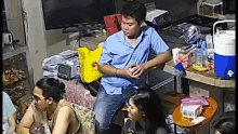a group of people are sitting around a table in a living room eating food .