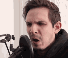 a man singing into a microphone with his mouth wide open