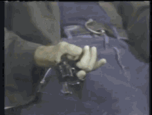 a person is holding a gun in their hand and there is a explosion behind them .