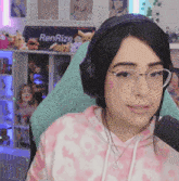 a woman wearing headphones and glasses is sitting in front of a renrize sign