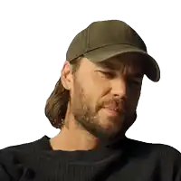 a man with a beard wearing a hat and a black shirt