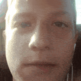 a close up of a person 's face with ear buds in