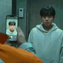 a person is taking a picture of another person with a cell phone