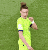 a female soccer player wearing a neon green jersey with a vw logo on it