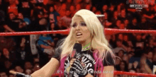 a woman in a wrestling ring is talking into a microphone and says it 's honestly all kinda weird